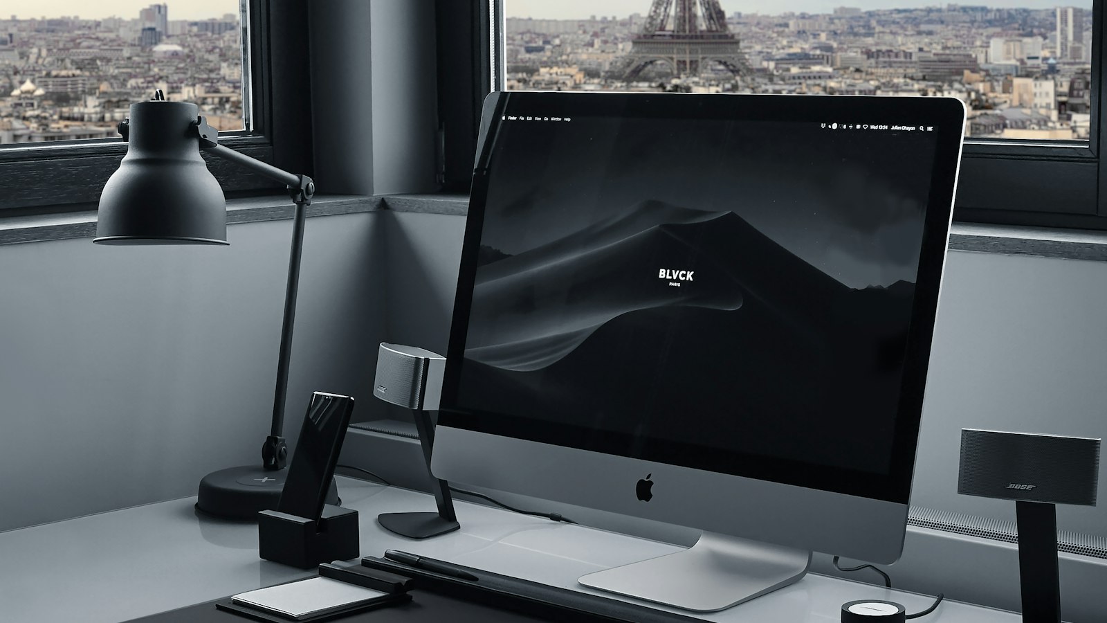 A minimalist desk with an iMac and a view through the window