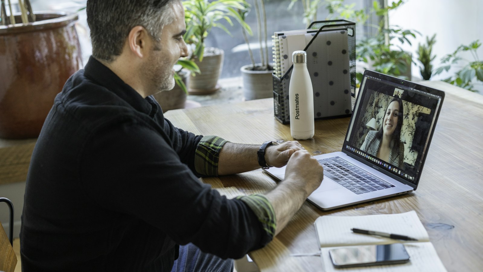 A man using a laptop for a video call at his desk